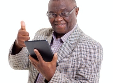 Senior man with thumbs up while on his tablet