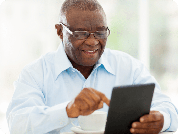 Senior man looking at his tablet in his house