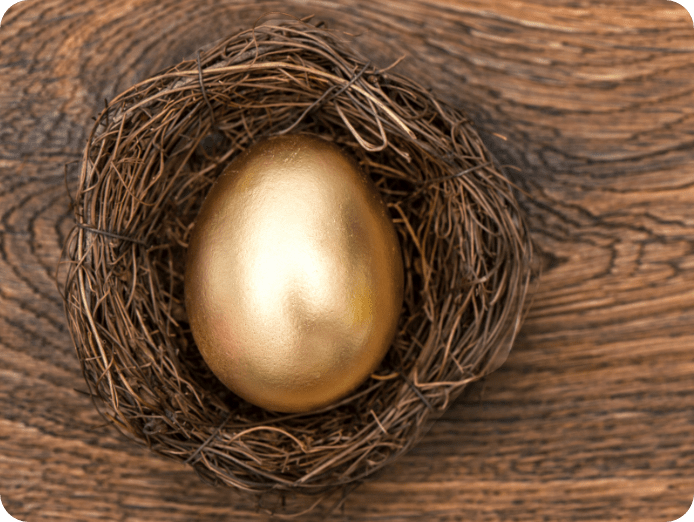 Golden egg in a nest on a wooden surface
