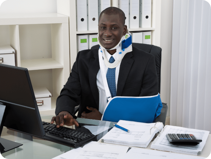 Man with neck collar and arm sling in his office typing